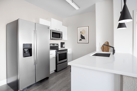 A modern kitchen with a refrigerator, oven, and microwave.