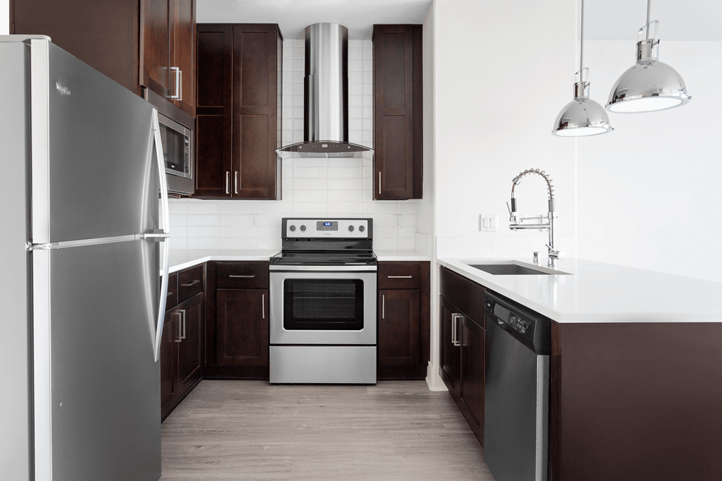 A modern kitchen with dark wood cabinets and stainless steel appliances.