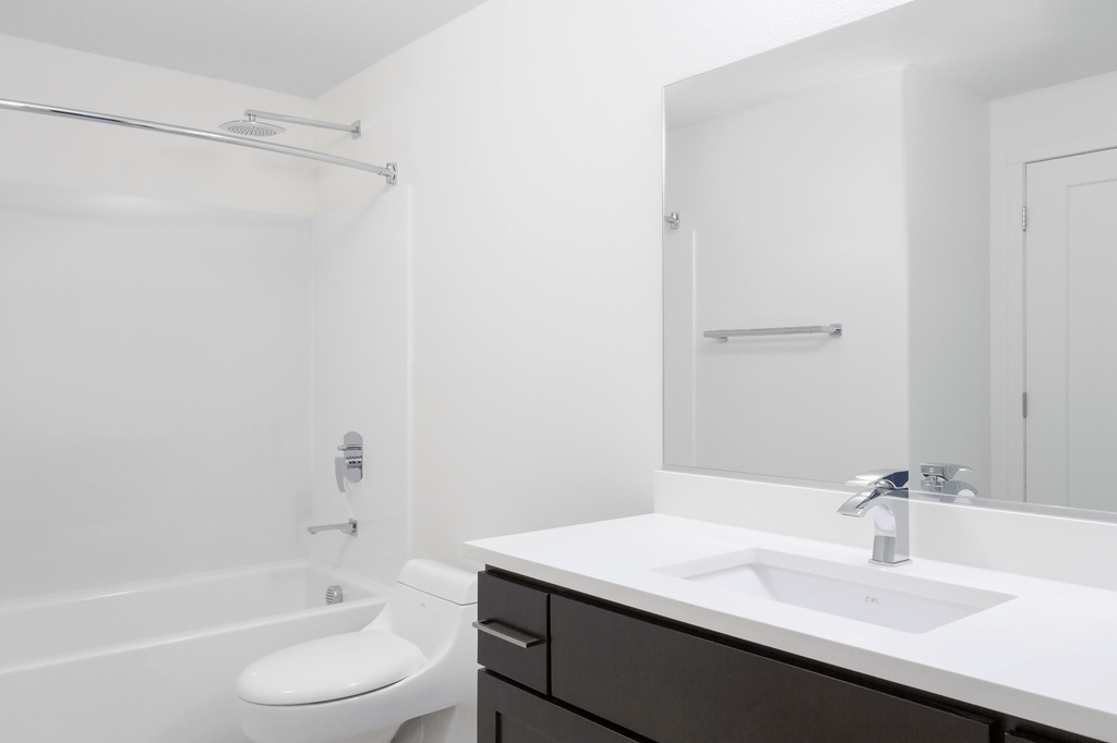 A white bathroom with a toilet, sink, and shower.