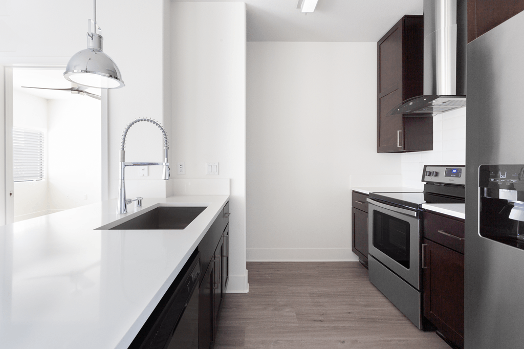 A modern kitchen with dark brown cabinets and stainless steel appliances.