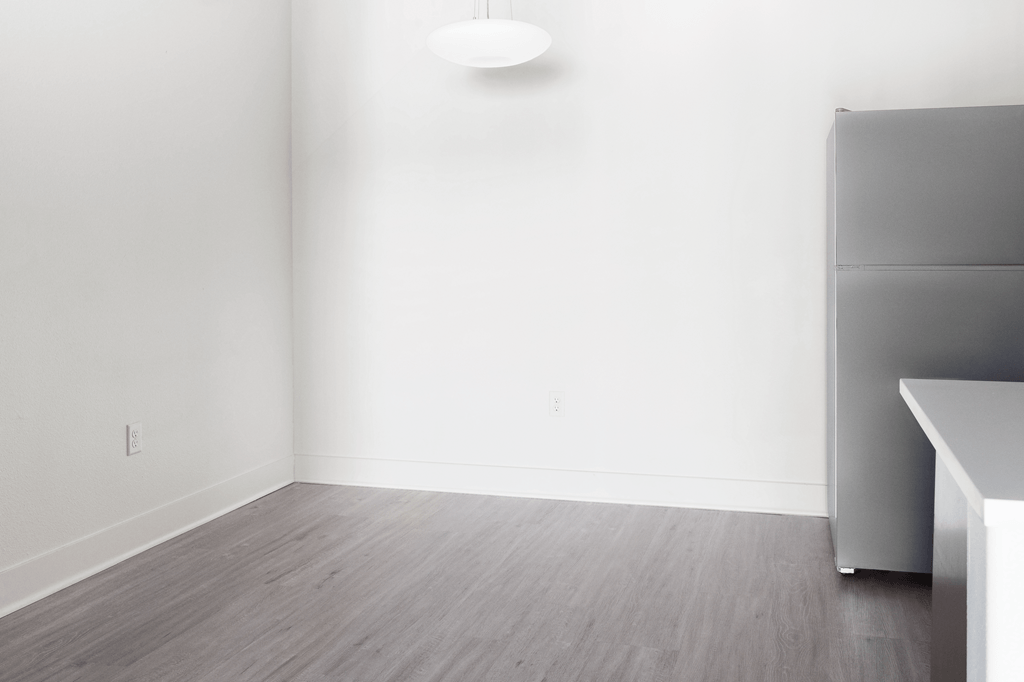 A room with a grey floor and a white wall with a light on.