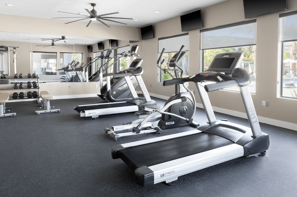 A gym with treadmills and elliptical machines.