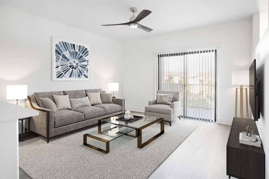 A living room with a grey couch, a coffee table, and a ceiling fan.