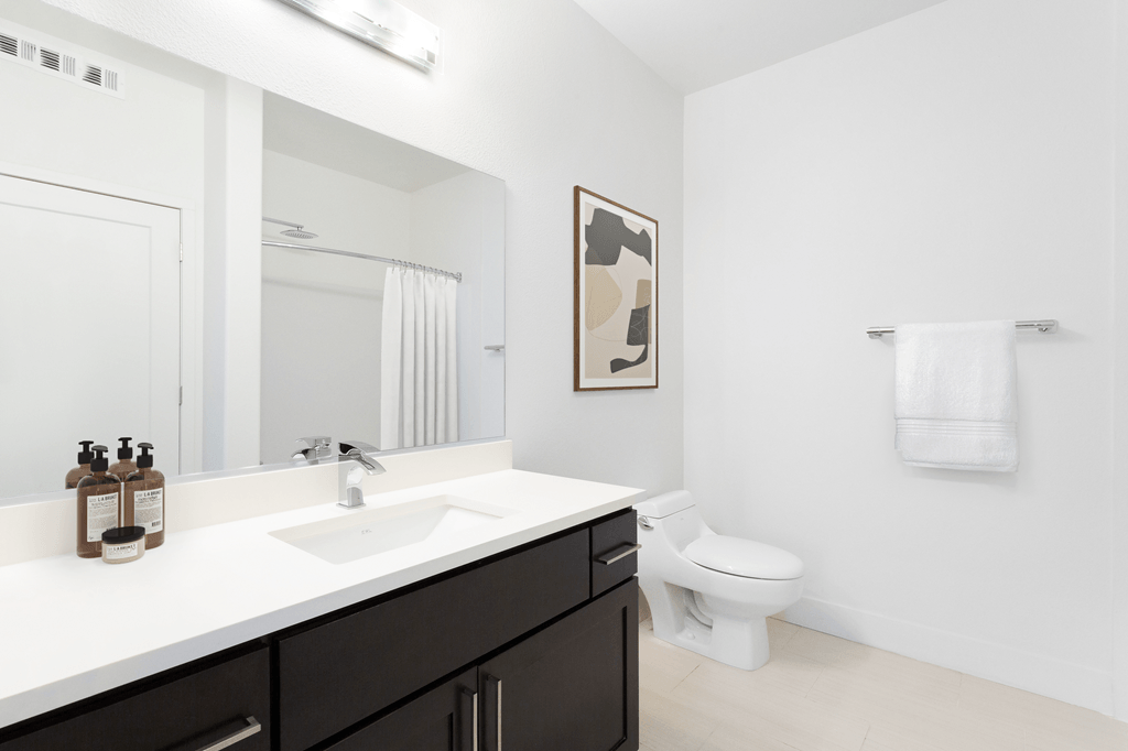 A bathroom with a white sink and a toilet.