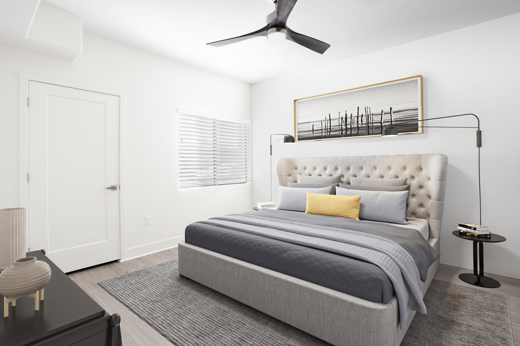 A bedroom with a large bed and a ceiling fan.