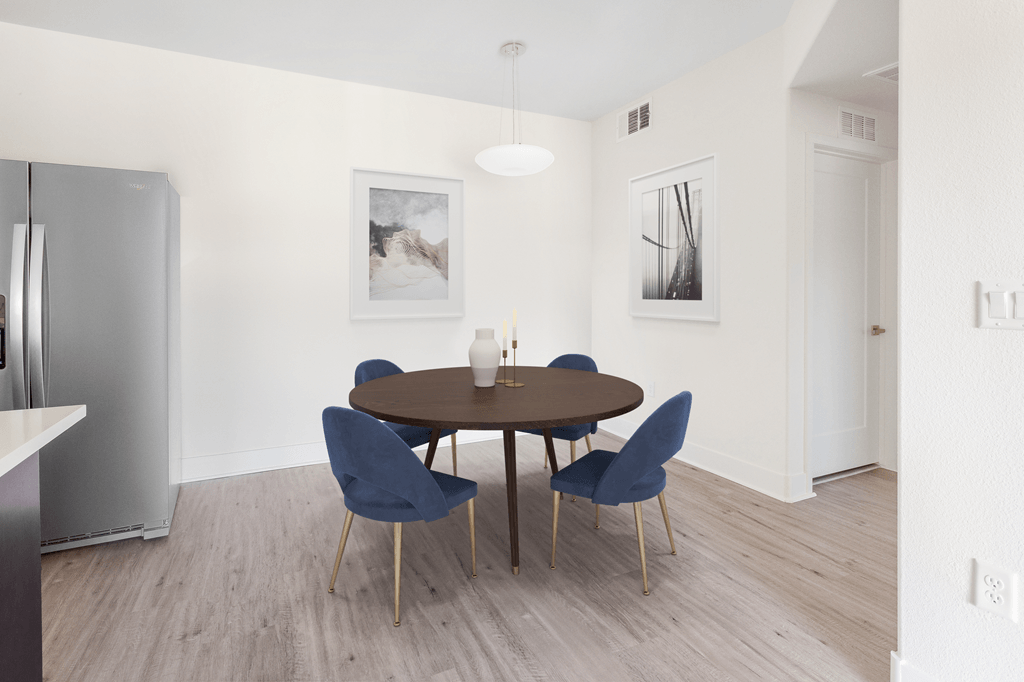 A modern dining room with a round table and chairs.