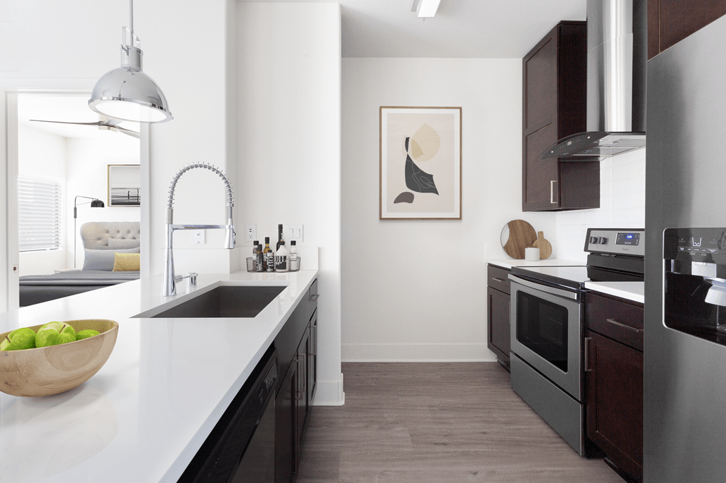 A modern kitchen with a bowl of green apples on the counter.