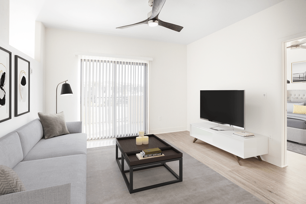 A modern living room with a grey sofa, a black coffee table, and a flat screen TV.