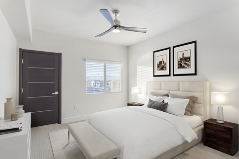 A bedroom with a large bed and a ceiling fan.