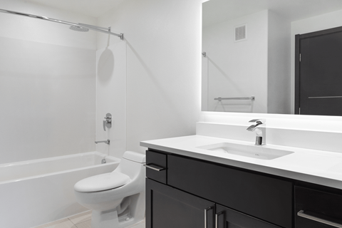 A white toilet sits next to a white sink in a bathroom.