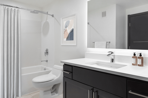 A bathroom with a white toilet, a white sink, and a white bathtub.