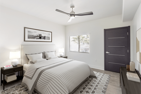 A bedroom with a large bed and a ceiling fan.