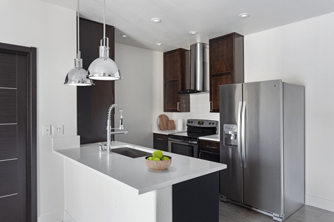 A modern kitchen with a stainless steel refrigerator and a white countertop.