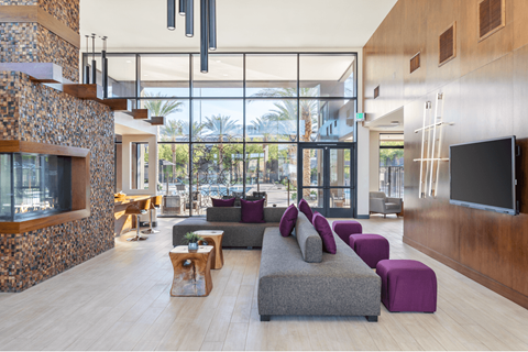 A modern living room with a stone fireplace and a large window.
