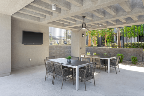 A patio with a table and chairs and a television.