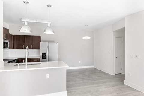 A kitchen with white countertops and brown cabinets.