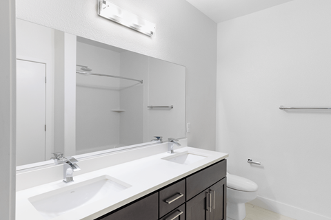 A bathroom with a white sink and a mirror above it.