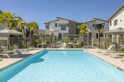 A swimming pool in front of a row of houses.