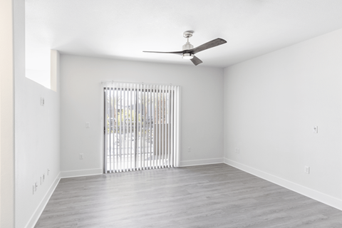 A room with a sliding door and a ceiling fan.