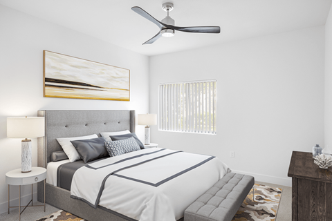 A bedroom with a large bed and a ceiling fan.