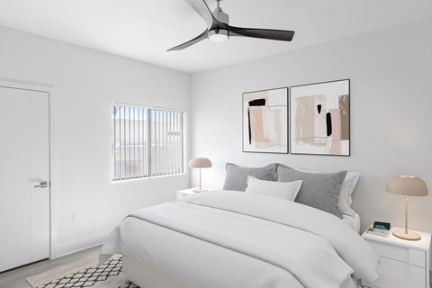 A bedroom with a bed, nightstand, and a ceiling fan.