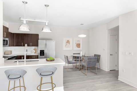 A kitchen with a bar area and a dining table.