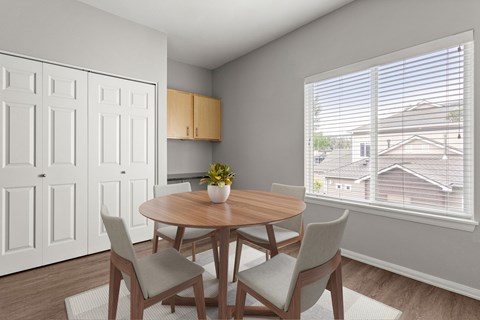 A dining room with a round wooden table and four chairs.
