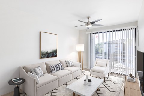 A living room with a white couch, a coffee table, and a painting on the wall.
