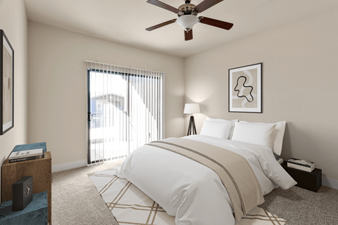 A bedroom with a large bed and a ceiling fan.