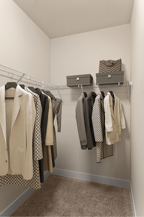 A row of clothes hanging on a rack in a room.