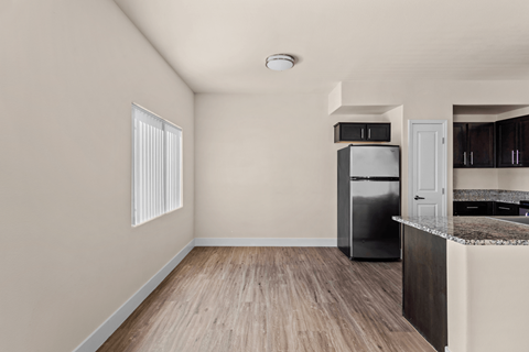 A kitchen with a refrigerator, cabinets, and a countertop.