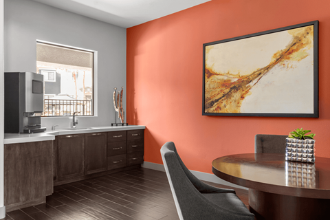 A modern kitchen with a wooden table and a grey chair.