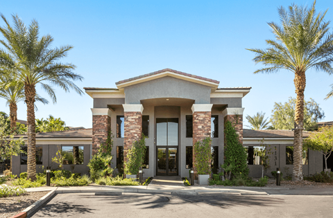 A modern building with palm trees in front.