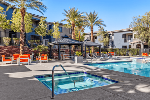 A swimming pool surrounded by palm trees and lounge chairs.