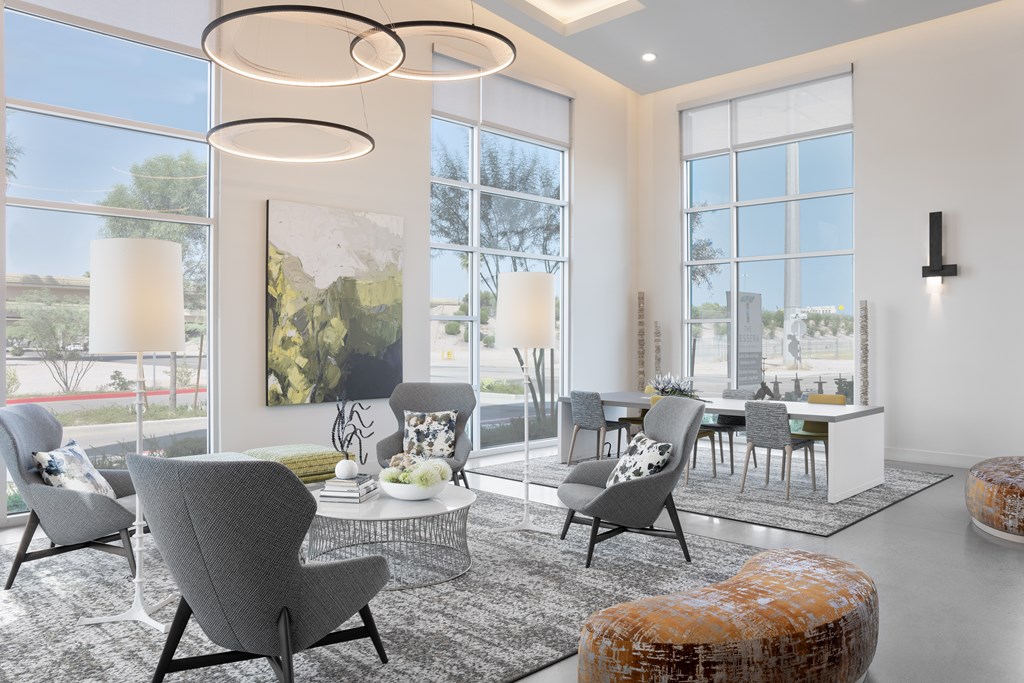 A modern living room with grey chairs and a large window.