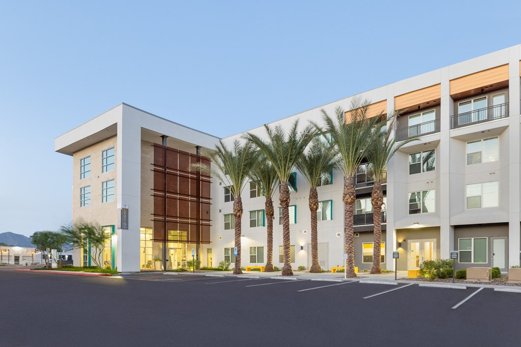 A modern building with palm trees in front.