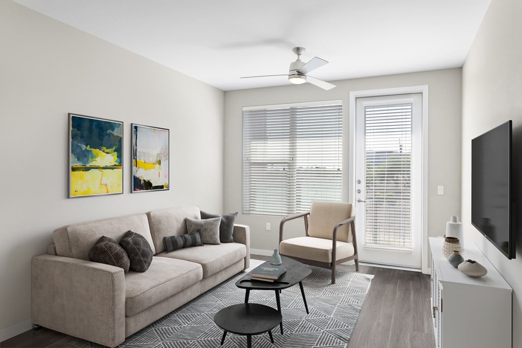 A living room with a couch, chair, and television.