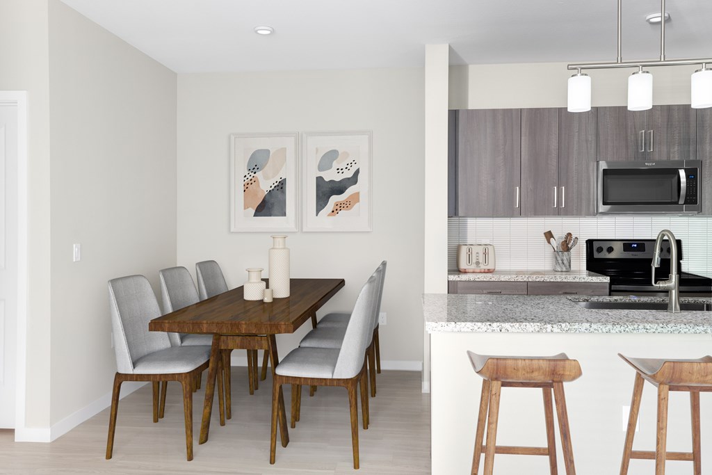 A kitchen with a dining table and chairs.