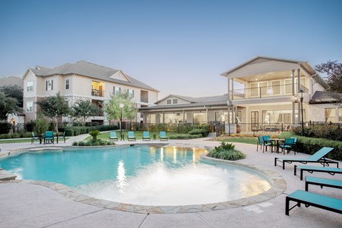 A large house with a pool in front.
