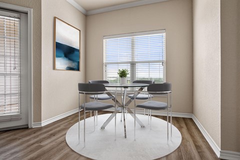 A dining room with a white table and chairs.