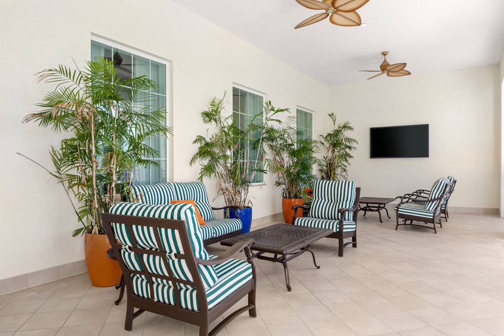 A living room with striped chairs and a flat screen TV.