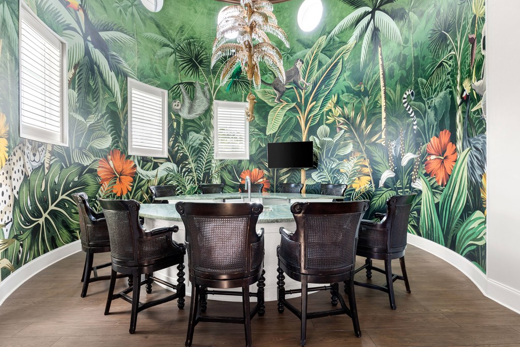 A room with a green wallpaper and a table with chairs.