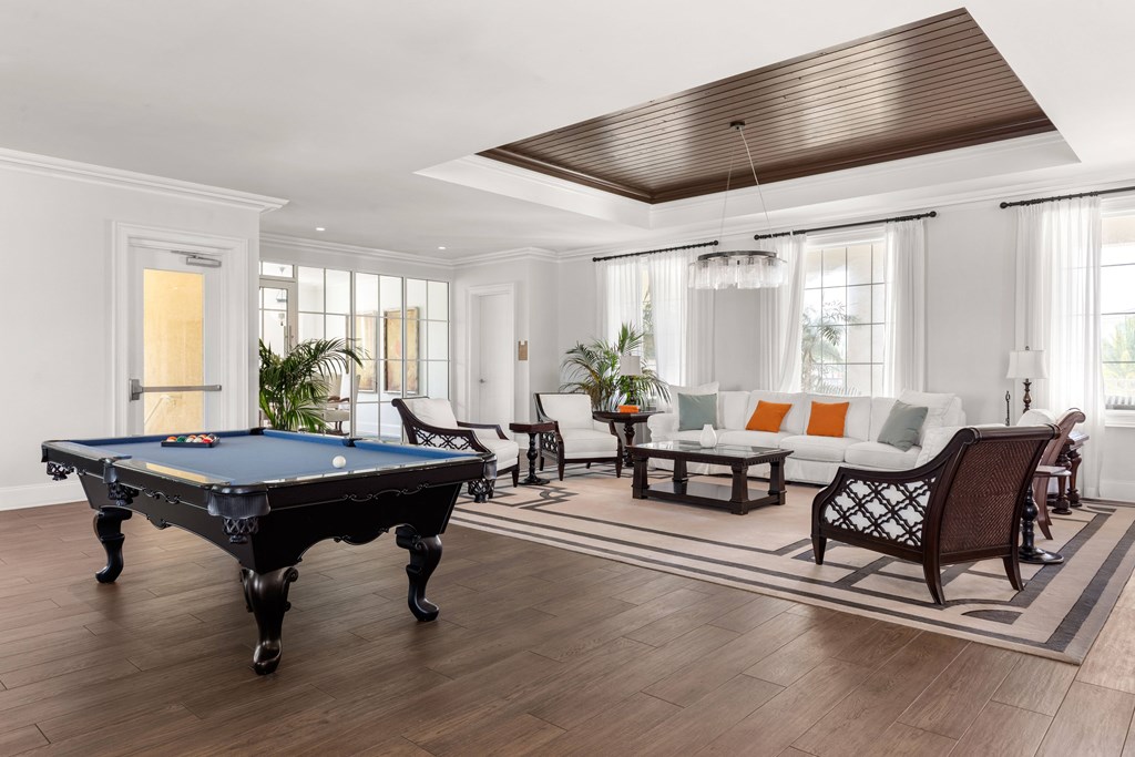 A pool table is in the middle of a living room.