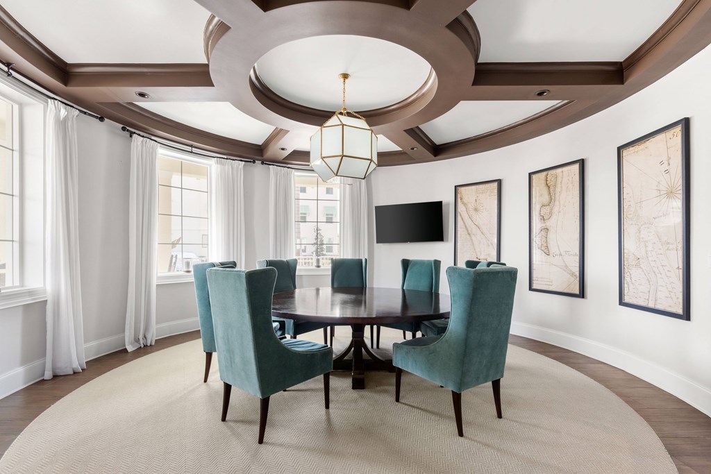 A dining room with a round table and chairs.
