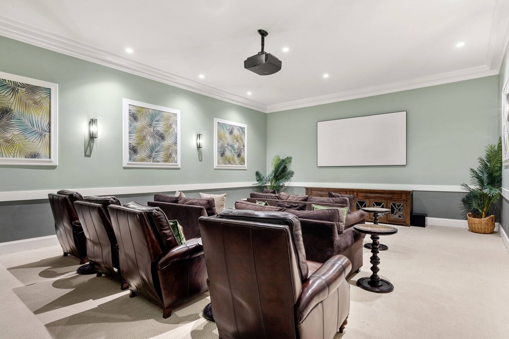 A room with brown leather chairs and a whiteboard on the wall.