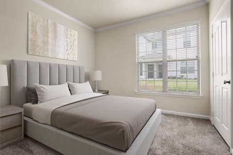 A bedroom with a large bed and a window with blinds.