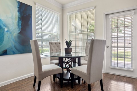 A dining room with a glass table and chairs.