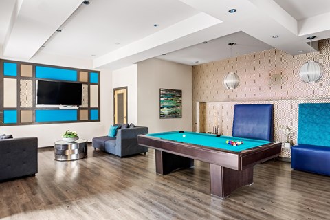 A room with a pool table and a television.