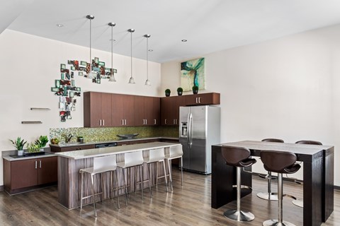 A modern kitchen with a bar area and a refrigerator.