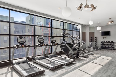A gym with treadmills, elliptical machines, and other exercise equipment.